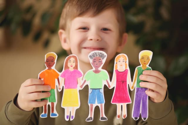 boy-holding-paper-homemade-garland-of-people-